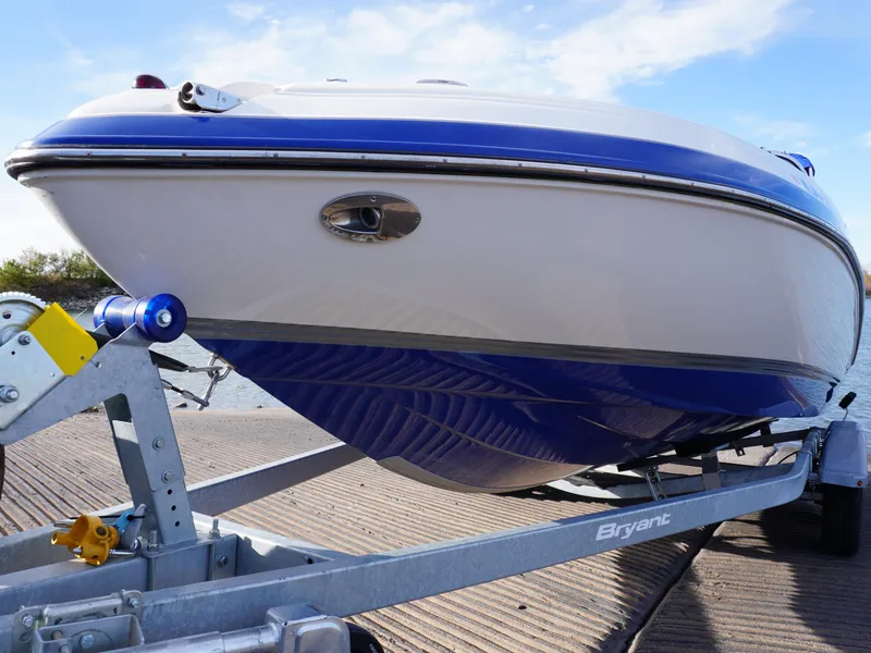 Slide: The Image of 2013 Bryant 220 boat on trailer, blue and white hull, ready for launch. - 3