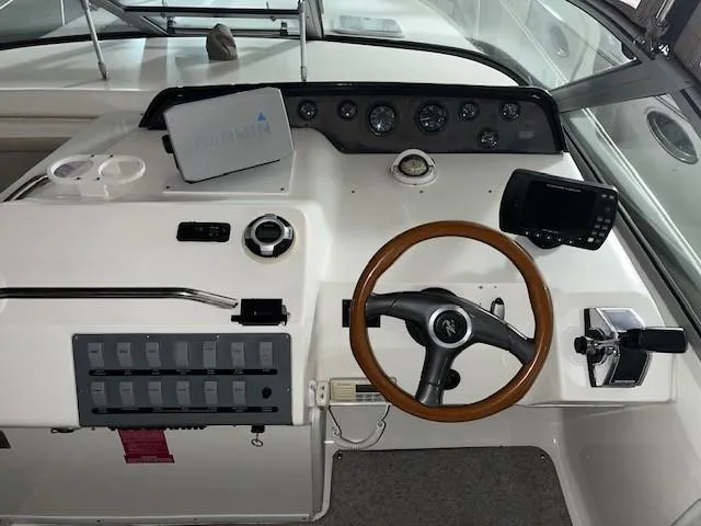 Slide: The Image of 1996 Sea Ray 290 Sundancer helm with steering wheel, gauges, and navigation equipment. - 10