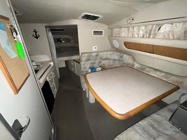 Slide: The Image of 1996 Sea Ray 290 Sundancer cabin interior with dining area and kitchenette. - 12