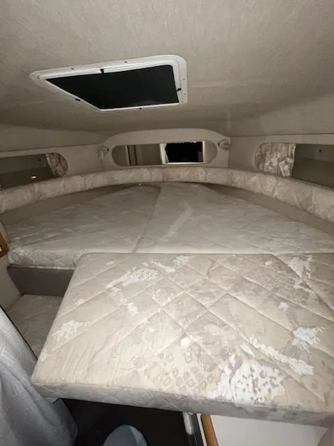 Slide: The Image of 1996 Sea Ray 290 Sundancer cabin interior with cushioned seating and overhead hatch. - 14