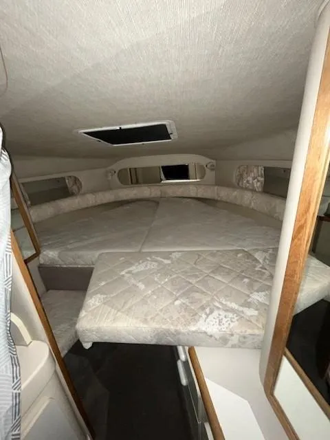 Slide: The Image of 1996 Sea Ray 290 Sundancer cabin interior with bed and storage. - 15