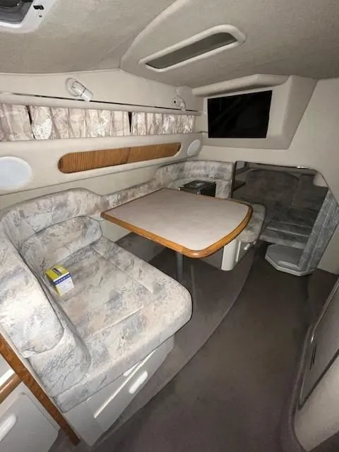 Slide: The Image of 1996 Sea Ray 290 Sundancer cabin interior with dining area and seating. - 16