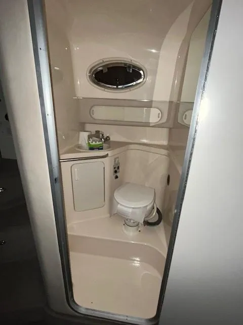 Slide: The Image of 1996 Sea Ray 290 Sundancer bathroom with compact toilet and sink. - 18
