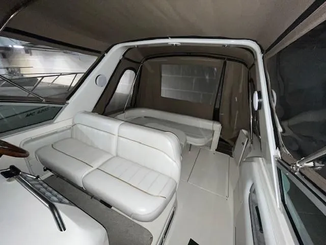 Slide: The Image of Interior of a 1996 Sea Ray 290 Sundancer boat with white seating and enclosed cabin. - 21