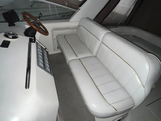 Slide: The Image of 1996 Sea Ray 290 Sundancer interior with white seating and helm. - 8