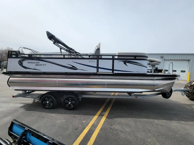 Slide: The Image of 2023 Angler Qwest 2285 Fish N Cruise pontoon boat on trailer, parked outdoors. - 10