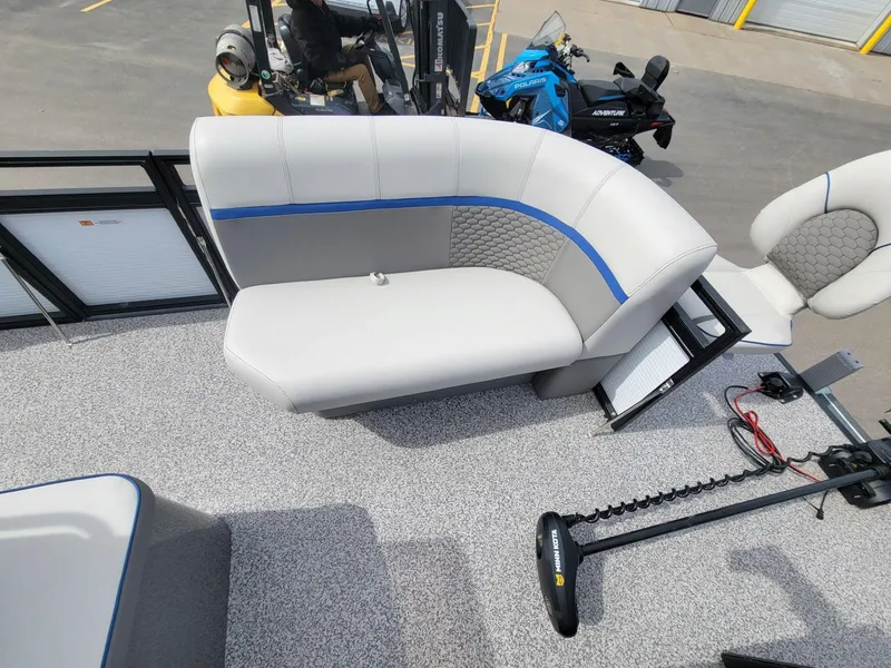 Slide: The Image of 2023 Angler Qwest 2285 Fish N Cruise boat interior with gray seating and blue accents. - 16