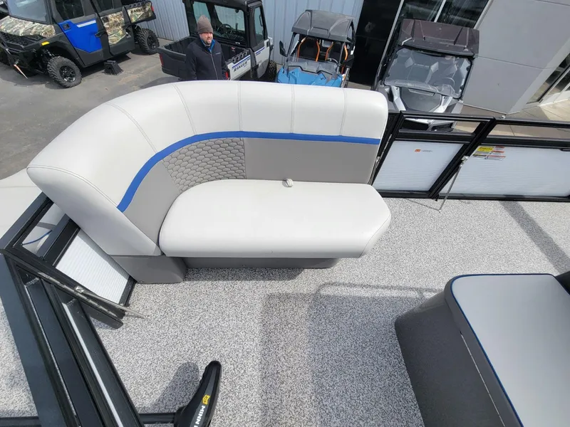 Slide: The Image of 2023 Angler Qwest 2285 Fish N Cruise boat interior with gray seating and blue accents. - 17