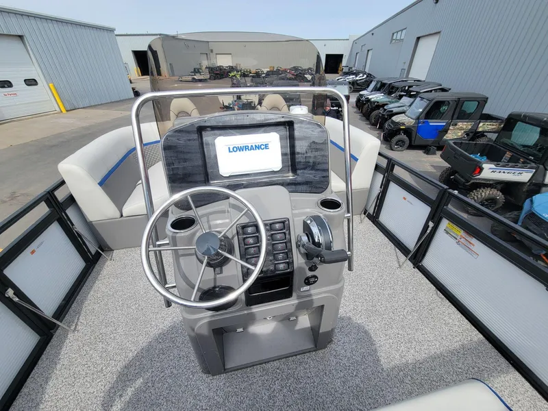Slide: The Image of 2023 Angler Qwest 2285 Fish N Cruise boat dashboard with Lowrance display and steering wheel. - 23