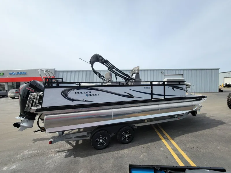 Slide: The Image of 2023 Angler Qwest 2285 Fish N Cruise pontoon boat on trailer in parking lot. - 3