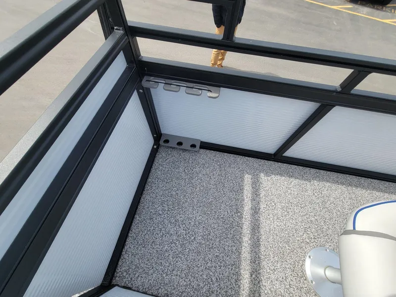 Slide: The Image of 2023 Angler Qwest 2285 Fish N Cruise boat interior with rod holders and carpeted floor. - 34