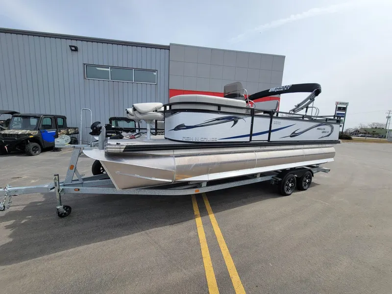 Slide: The Image of 2023 Angler Qwest 2285 Fish N Cruise pontoon boat on trailer, parked outside a building. - 7