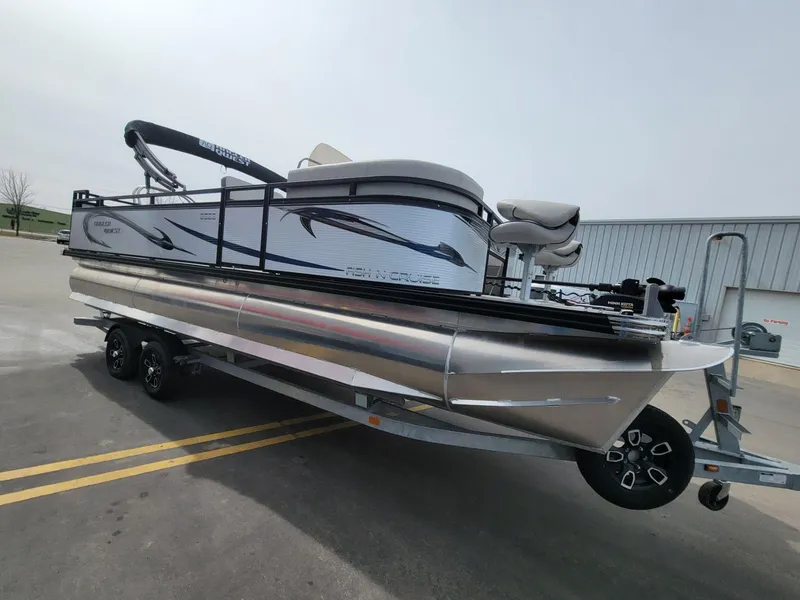 Slide: The Image of 2023 Angler Qwest 2285 Fish N Cruise pontoon boat on trailer, parked outdoors. - 9