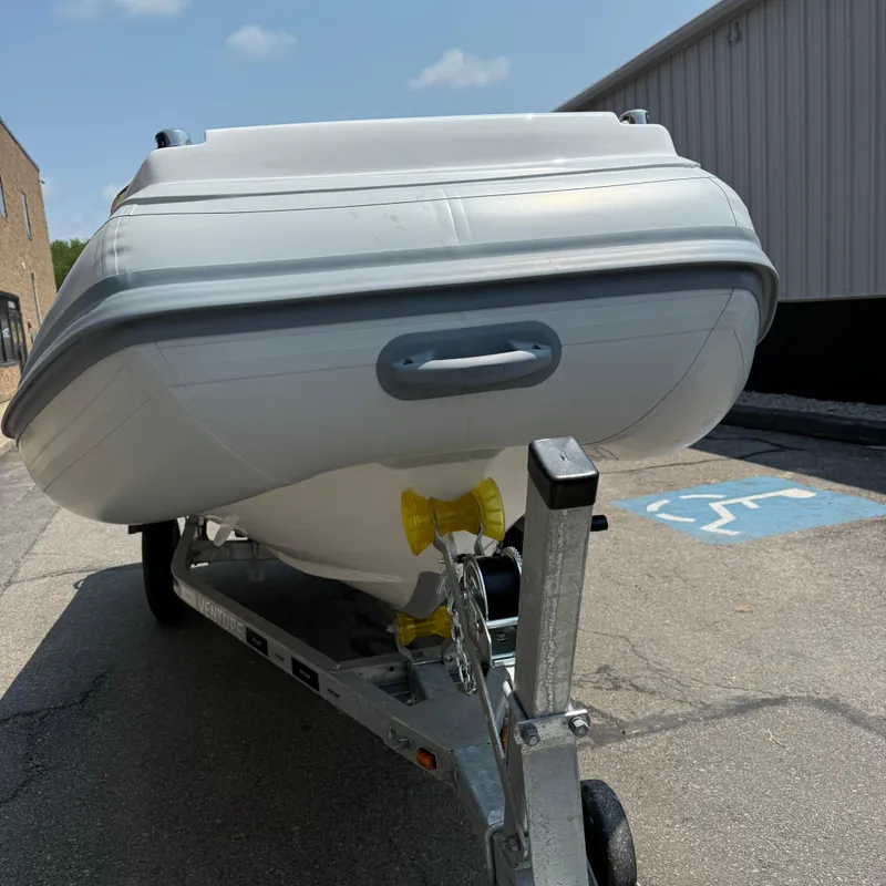 Slide: The Image of 2025 Highfield Sport 420 boat on trailer, parked in a lot under clear skies. - 9