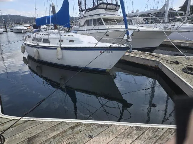 Slide: The Image of 1984 Newport 33 sailboat docked at a marina with blue sail cover. - 11