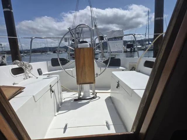 Slide: The Image of Cockpit view of 1984 Newport 33 sailboat with steering wheel, docked in marina. - 8