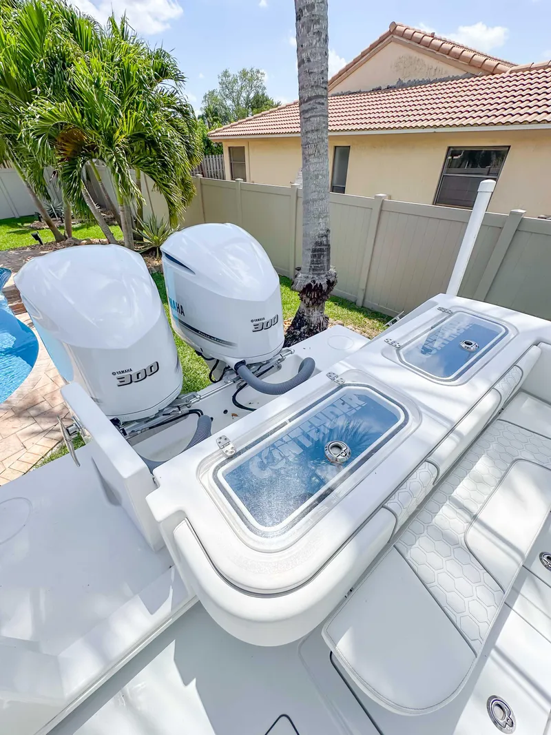 Slide: The Image of 2021 Contender 30 Tournament boat with dual 300 horsepower engines, parked near a poolside. - 14