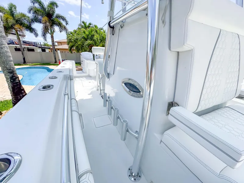 Slide: The Image of 2021 Contender 30 Tournament boat with sleek white interior and chrome accents, near a poolside. - 18