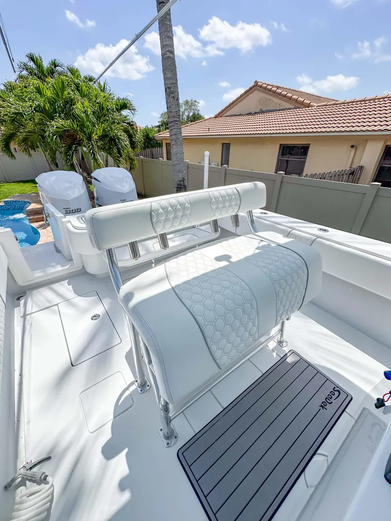 Slide: The Image of 2021 Contender 30 Tournament boat with white seating and dual engines, in a sunny backyard setting. - 26