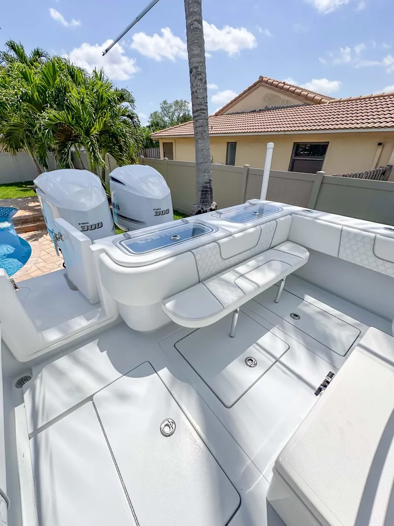 Slide: The Image of 2021 Contender 30 Tournament boat with dual engines, spacious deck, and seating in a sunny backyard. - 28