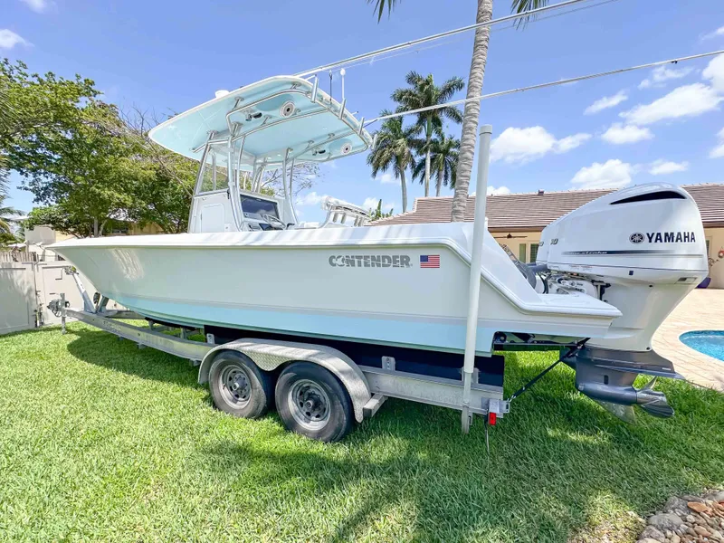 Slide: The Image of 2021 Contender 30 Tournament boat on trailer with Yamaha engine, parked on grass. - 6