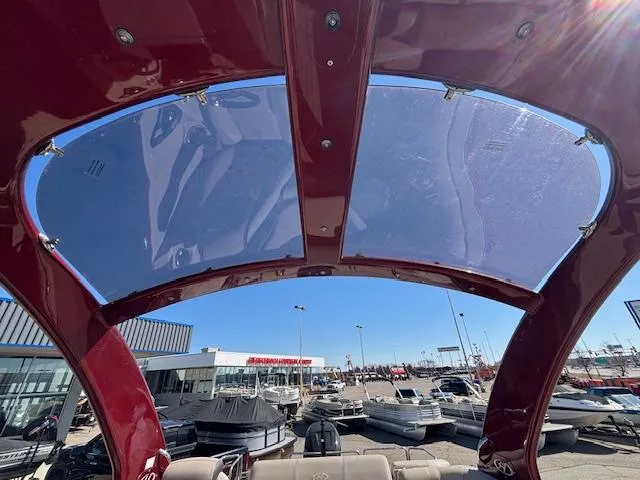 Slide: The Image of 2018 Harris Crowne SL 250 boat with a red canopy, displayed at a marina. - 11