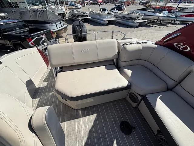 Slide: The Image of 2018 Harris Crowne SL 250 boat interior with beige seating at a marina. - 21