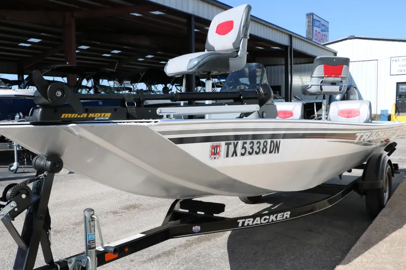 Slide: The Image of 2016 Tracker Pro 160 boat on trailer, featuring seating and motor, parked outdoors. - 6