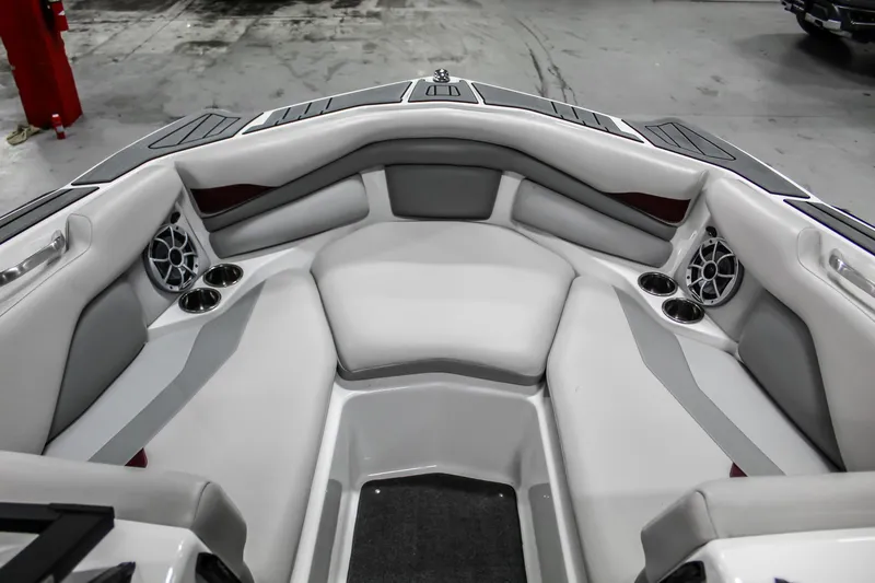Slide: The Image of 2018 Axis A22 boat interior with gray seating, cup holders, and speakers. - 19