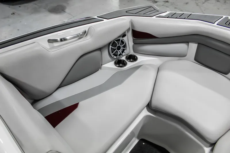 Slide: The Image of 2018 Axis A22 boat interior with gray seating, cup holders, and speaker. - 20