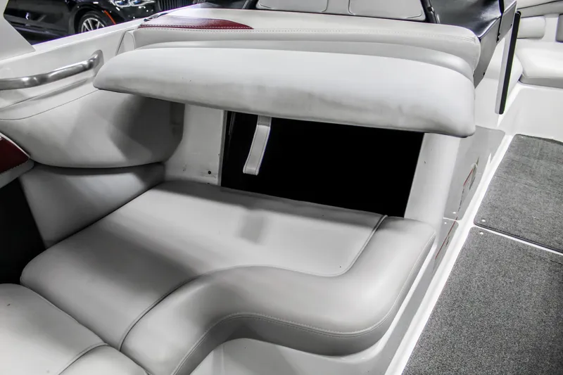 Slide: The Image of 2018 Axis A22 boat interior with open storage compartment and cushioned seating. - 25