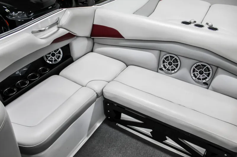 Slide: The Image of 2018 Axis A22 boat interior with white seating, cup holders, and speakers. - 28