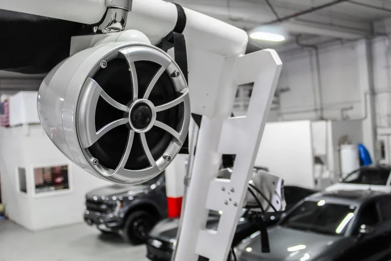 Slide: The Image of 2018 Axis A22 boat speaker in a garage with cars in the background. - 33