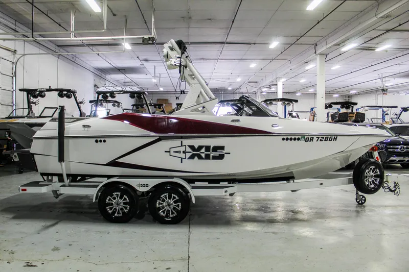 Slide: The Image of 2018 Axis A22 boat in showroom, white with red accents, on a trailer. - 7
