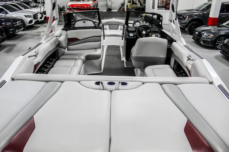 Slide: The Image of 2018 Axis A22 boat interior with gray seating and modern dashboard in showroom. - 9