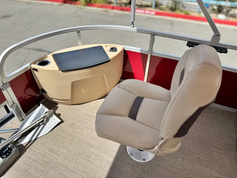 Slide: The Image of 2019 Sun Tracker Fishin' Barge 24 DLX interior with beige seating and control panel. - 11