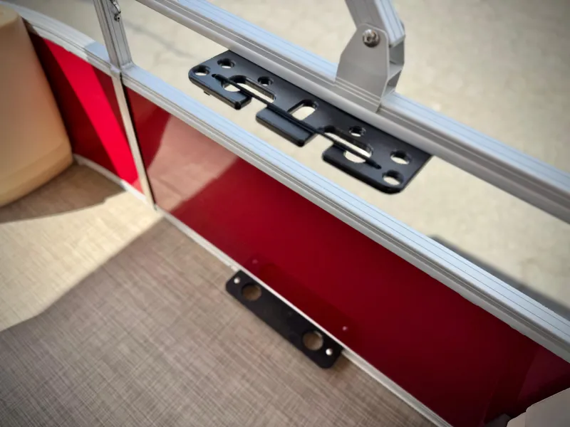 Slide: The Image of 2019 Sun Tracker Fishin' Barge 24 DLX interior detail with red panel and mounting bracket. - 14