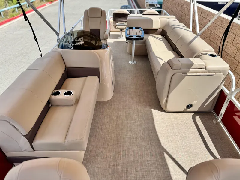 Slide: The Image of 2019 Sun Tracker Fishin' Barge 24 DLX interior with beige seating and cup holders. - 15