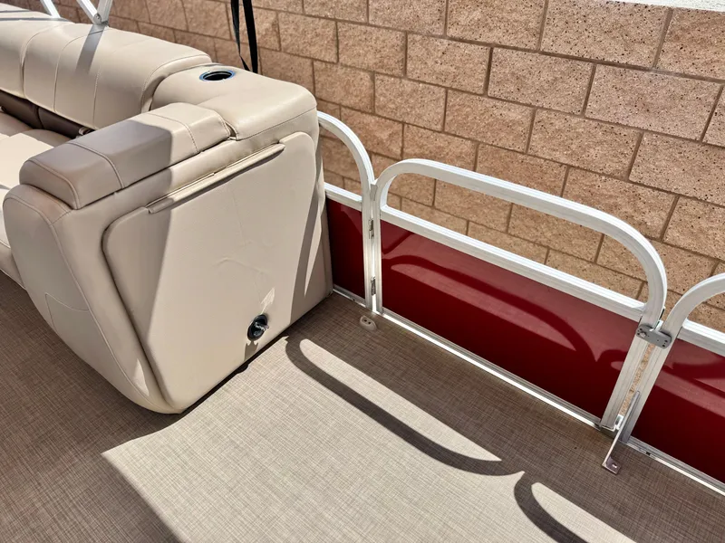 Slide: The Image of 2019 Sun Tracker Fishin' Barge 24 DLX interior with beige seating and red paneling. - 16