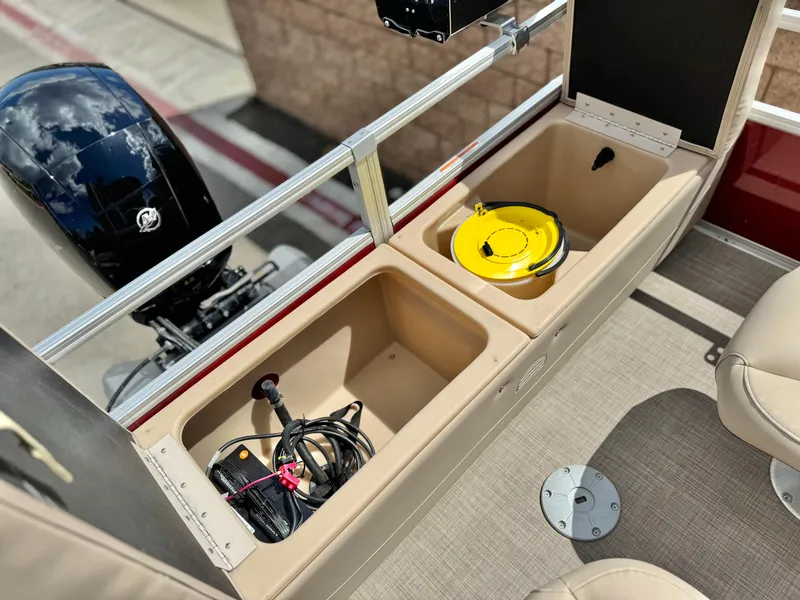 Slide: The Image of 2019 Sun Tracker Fishin' Barge 24 DLX storage compartments with fishing gear and motor view. - 23
