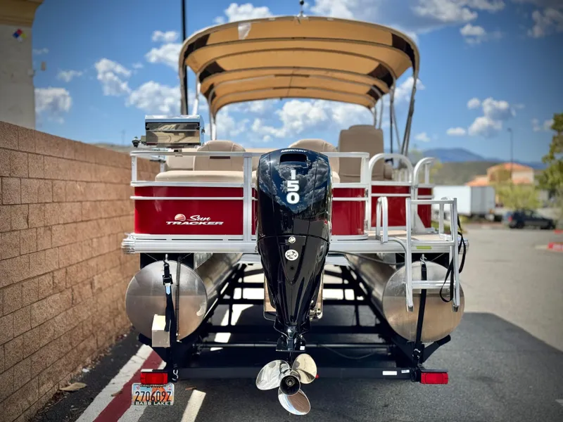 Slide: The Image of 2019 Sun Tracker Fishin' Barge 24 DLX pontoon boat with 150 HP engine, parked outdoors. - 5