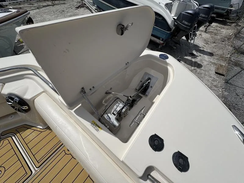 Slide: The Image of 2021 Grady-White Canyon 326 boat anchor compartment with open hatch, showcasing storage and mechanism. - 10
