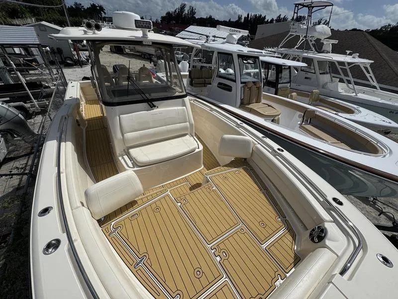 Slide: The Image of 2021 Grady-White Canyon 326 boat with spacious deck and seating, docked alongside similar vessels. - 12