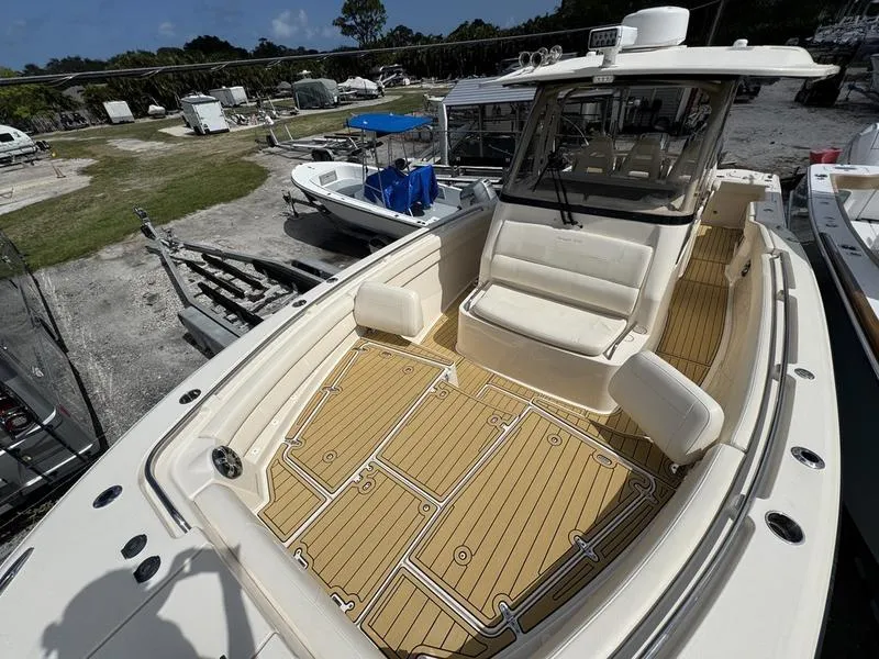 Slide: The Image of 2021 Grady-White Canyon 326 boat with spacious deck and seating, docked outdoors. - 13