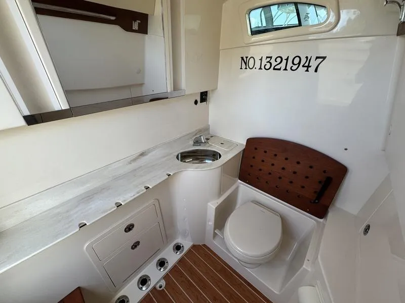 Slide: The Image of 2021 Grady-White Canyon 326 boat interior with sink, toilet, and storage. - 18