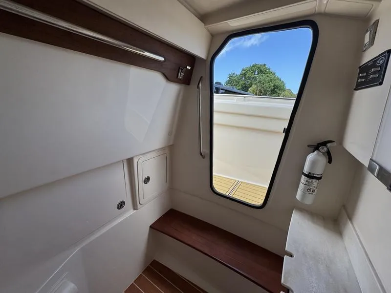 Slide: The Image of 2021 Grady-White Canyon 326 cabin interior with seating, window, and fire extinguisher. - 19