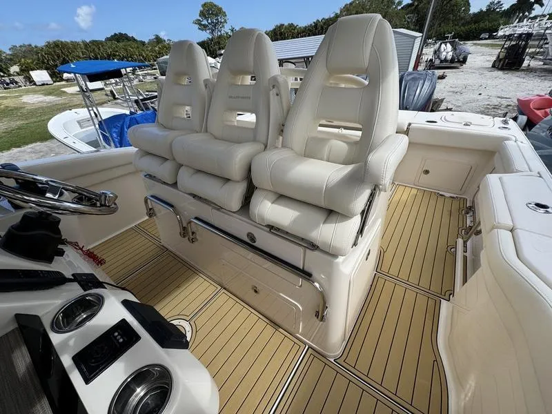 Slide: The Image of 2021 Grady-White Canyon 326 boat interior with plush seating and modern dashboard. - 21
