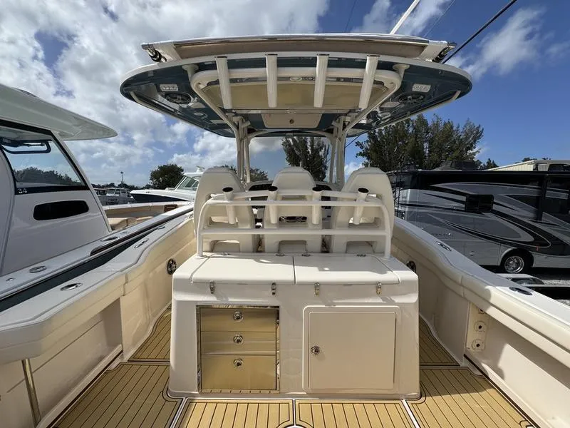 Slide: The Image of 2021 Grady-White Canyon 326 boat interior with seating and storage, under a clear sky. - 27