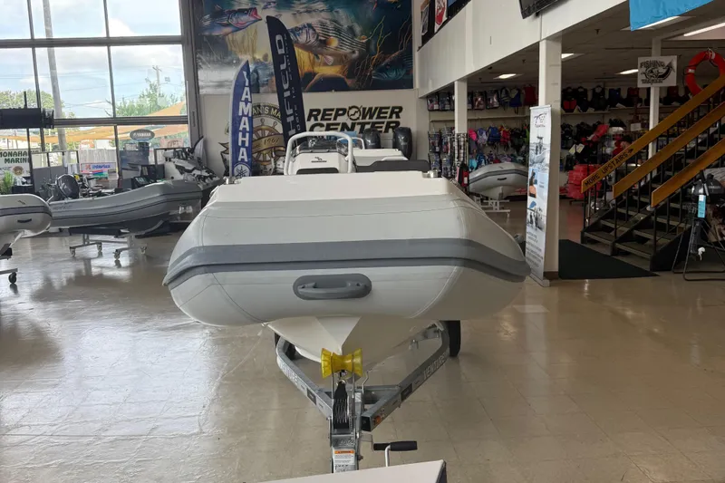 Slide: The Image of 2025 Highfield Sport 460 inflatable boat displayed in a showroom on a trailer. - 2