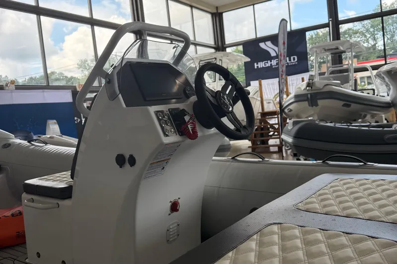 Slide: The Image of 2025 Highfield Sport 460 boat interior with steering wheel and control panel in showroom. - 6
